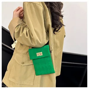 Detail of green velvet crossbody bag with gold chain strap and square metal lock