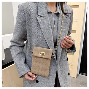 Detail of vintage brown corduroy crossbody bag with gold chain and metal twist lock