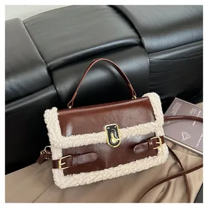 Détail du patchwork en laine d'agneau et fermoir doré sur le sac à main en cuir brun