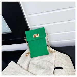 Detail of green quilted mini bag with gold chain strap and metal turn-lock closure