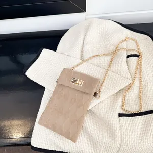 Maillard vintage khaki quilted crossbody bag with gold chain strap on tweed jacket