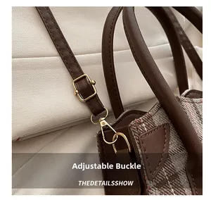 Detail of adjustable gold buckle and tweed fabric on the crossbody bucket bag