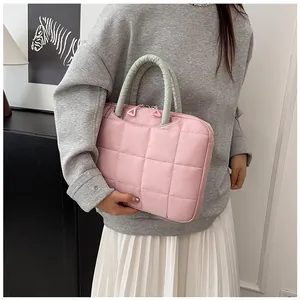 Dettaglio della borsa porta pc trapuntata rosa con manici verdi e zip doppia