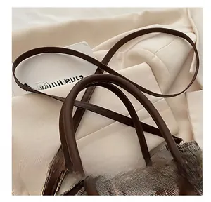 Detailed macro view of the premium plaid bucket bag with leather handles and strap