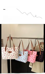 Dettaglio di borse tote con stampa ciliegia in quattro colori con manici in finta pelle