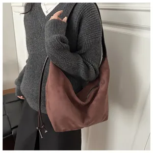 Detail of dark brown suede hobo bag showing its large capacity and soft texture on shoulder