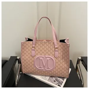 Detailed macro shot of the pink monogram tote bag texture and embossed M logo detail