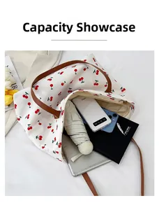 Vista capacità della borsa beige con stampa ciliegie contenente tablet e cellulare