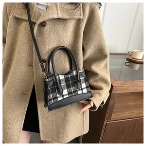 Chic black and white checkered mini bucket bag styled with a brown wool coat