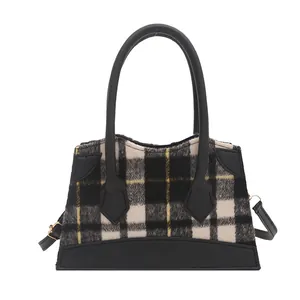 Fashionable black and white tweed plaid bucket bag with yellow accents and leather handles