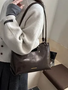 Deep brown faux leather handbag with gold lettering and adjustable long shoulder strap