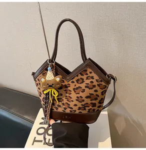 Detailansicht der Handtasche mit Leopardenmuster, Lederbesatz und Bären-Anhänger-Detail
