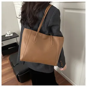 Brown leather tote bag featuring vertical stitching and long shoulder straps for daily use