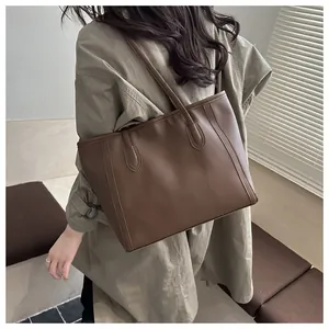 Detail view of a vintage dark brown tote bag on model showing premium leather texture