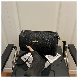 Détail de la texture en cuir tressé noir et logo doré Fashion sur le sac cylindre