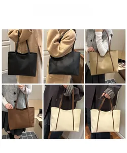 Nahaufnahme minimalistischer Tragetaschen in Schwarz und Khaki mit feinen Nähten