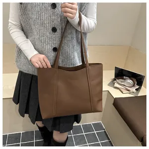 Makroaufnahme der dunkelbraunen Leder-Shopper mit Ziernähten und langen Schulterriemen