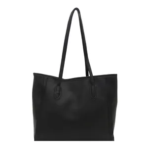 Classic black tote bag in matte faux leather with long handles for shoulder use