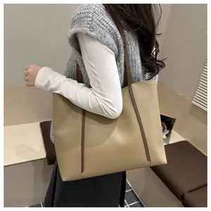 Detailansicht der khakifarbenen Tote Bag mit glatter Textur und braunem Schultergurt