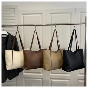 Vier minimalistische Tragetaschen aus Kunstleder in Creme, Braun, Khaki und Schwarz am Haken