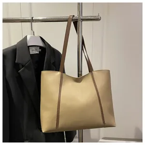 Detailansicht großer beiger Shopper mit braunen Trägern an einem eleganten Kleiderbügel