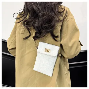 Achteraanzicht van witte pluche crossbody tas met gouden ketting en draaisluiting bij model