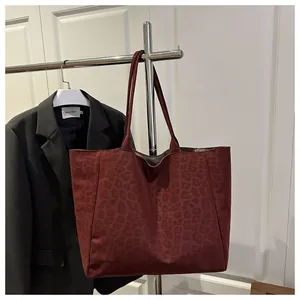 Détail du sac cabas bordeaux à imprimé léopard avec texture mate et doubles lanières