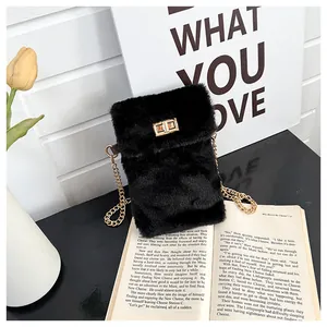 Detailed macro view of black faux fur plush handbag with gold metal twist lock and chain