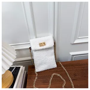 Detail of white sherpa fleece small handbag with gold turn-lock and chain strap