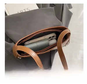 Vue détaillée de l'intérieur spacieux du sac baguette en cuir marron sur un blazer