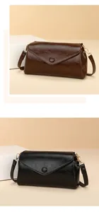 Detail van enveloppe crossbodytassen in donkerbruin en zwart geolied leer luxe