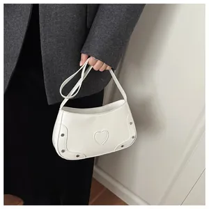 Détail du sac à main blanc en similicuir gaufré avec couture cœur et rivets métalliques chic