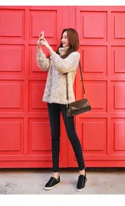 Detail van donkerbruine laks lederen envelop schoudertas gedragen met casual outfit