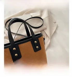 Detail of vintage brown quilted bucket bag with gold rivets and black leather trim