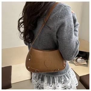 Sac à bandoulière marron texture crocodile avec patch cœur et rivets métalliques