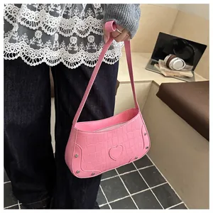 Sac à bandoulière rose en cuir de crocodile avec écusson cœur et rivets en métal
