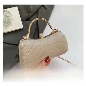Nahaufnahme der goldenen Abend-Clutch mit Kristallschnalle und elegantem Metallgriff