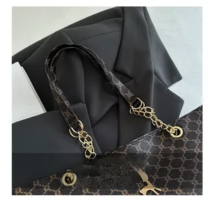 Detail of vintage tote bag featuring brown monogram pattern and deer charm accessory