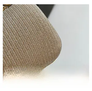 Makroaufnahme einer champagnergoldenen Abendtasche mit funkelnder Metallic-Textur