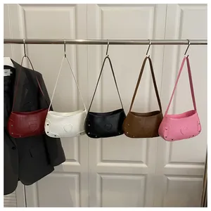 Détail de cinq couleurs de sacs bandoulière motif crocodile avec texture cœur et rivets