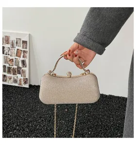 Makroaufnahme der glitzernden champagnergoldenen Abendtasche mit Strass und Metallgriff