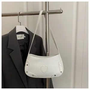 Vue détaillée du sac blanc motif crocodile avec cœur décoratif et rivets argentés