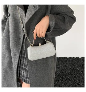 Detail der silbernen Glitzer-Abendtasche mit Metallgriff und Schmucksteinverschluss