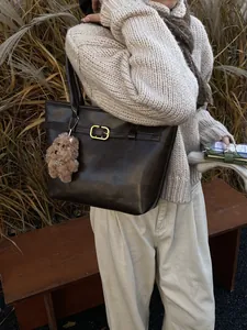 Große dunkelbraune Leder-Shopper-Tasche mit goldener Schnalle und süßem Bärenanhänger