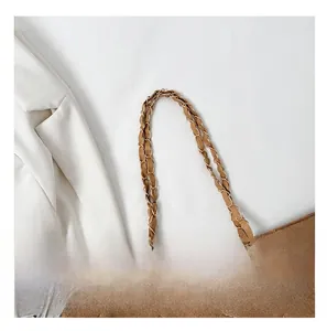 Detail of the golden chain strap and brown quilted velvet texture on the shoulder bag