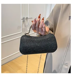 Detail der schwarzen Pailletten-Abendtasche mit Goldgriff und Kristallverschluss