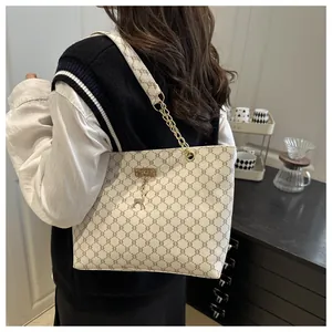 Detailed side view of a large tote bag with geometric pattern and gold chain strap
