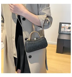 Detailansicht der schwarzen Pailletten-Abendtasche mit goldenem Rahmen und Kette