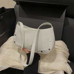 Sac à bandoulière blanc motif crocodile avec rivets argentés et détail de cœur