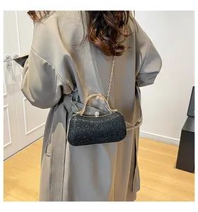 Details einer schwarzen Pailletten-Abendtasche mit goldenem Metallgriff und Kette